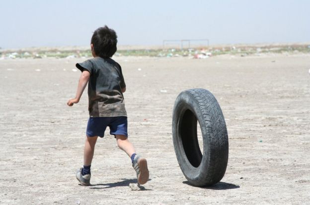 Niño jugando con un neumático.