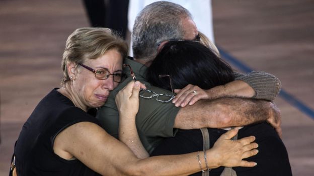 Familiares abrazados durante el funeral