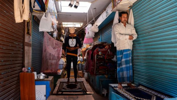 Muçulmano reza em frente ao comércio fechado em Nova Déli durante o Ramadã