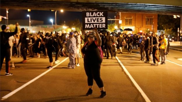 A protester in Rochester, New York holds a sign saying 'Black Lives Matter'