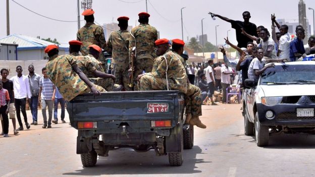 Sudanese demonstrators cheer as they drive towards a military vehicle. Khartoum 11 April 2019