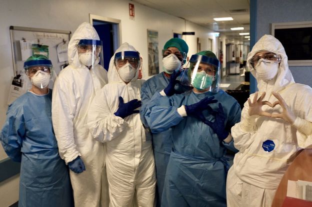 Members of staff at the hospital make heart signs to the camera