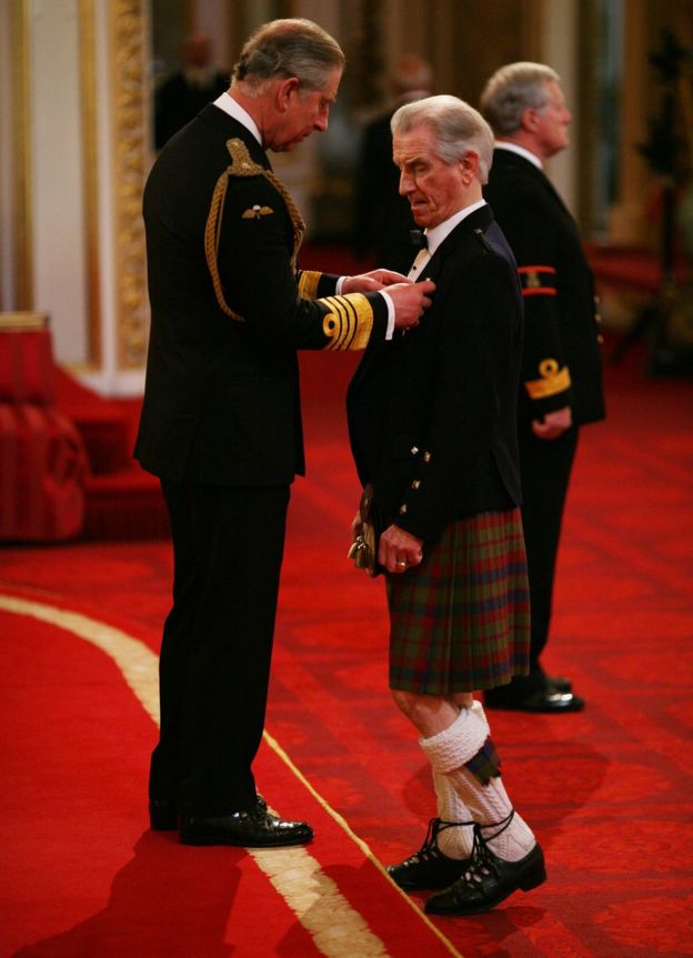 Mr. John Beattie from Glasgow is made an MBE by The Prince of Wales at Buckingham Palace.