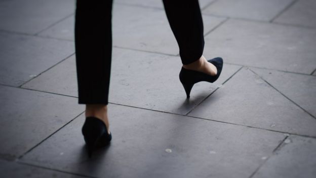 Woman's feet avoiding crack on pavement