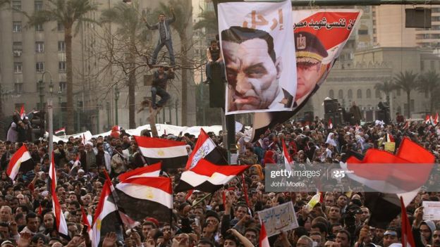 متظاهرون في ميدان التحرير، وسط القاهرة، يرفعون لافتة تطالب مبارك بالرحيل عن السلطة في أثناء ثورة 25 يناير 2011