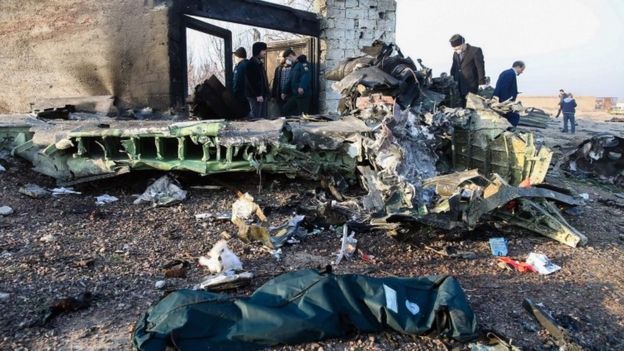 People stand near the wreckage after a Ukrainian plane carrying 176 passengers crashed near Imam Khomeini airport in Tehran on January 8, 2020