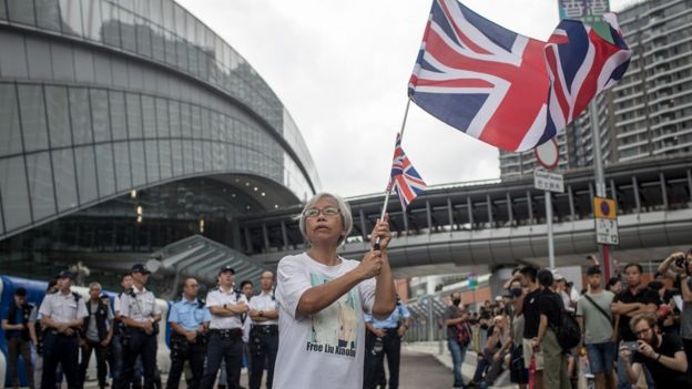 A protester waves a British flag in front of the West Kowloon railway station during a protest against the proposed extradition bill on July 7, 2019