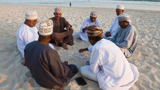 رجال يجلسون في الهواء الطلق في سلطنة عمان