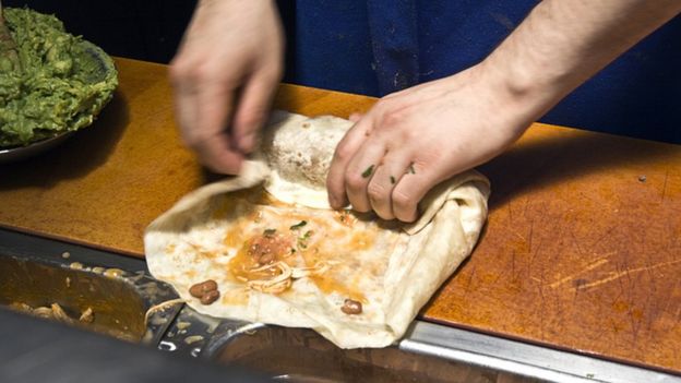 Una persona enrolla un burrito