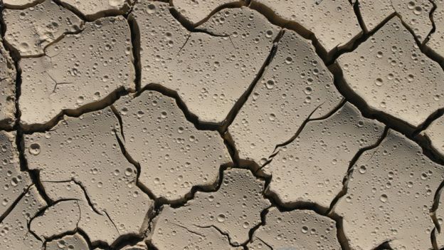 Dry, cracked earth with raindrops