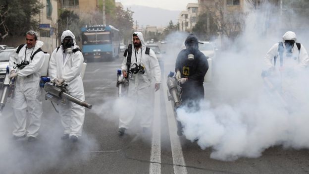 Workers disinfect a street in Tehran to prevent the spread of the Covid-19 virus (18 March 2020)