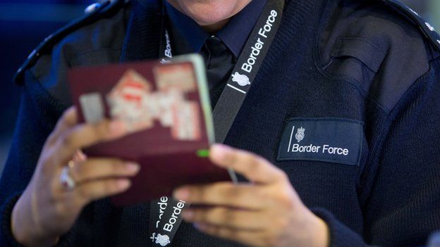 A Border Force officer checking passports at Terminal 2, Heathrow Airport in June