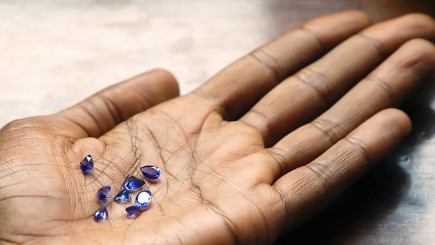 An outreached palm with tanzanite stones on it