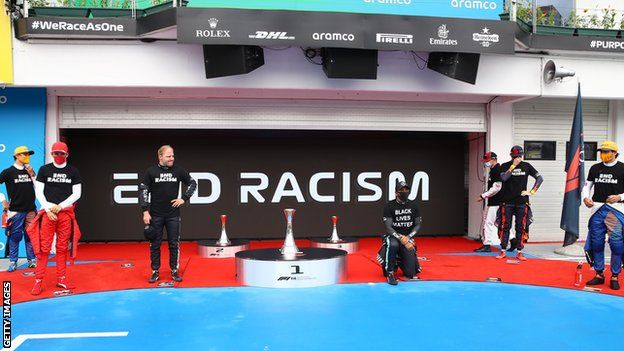 Lewis Hamilton takes the knee while other driver stand before the Hungarian Grand Prix
