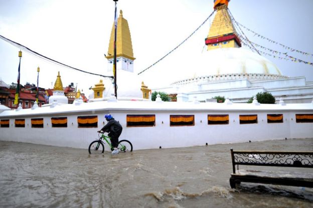 A cyclist travelling in a flooded water in the premises of Boudhanath Stupa, a UNESCO World Heritage Site in Kathmandu, Nepal on Thursday, September 06, 2018.