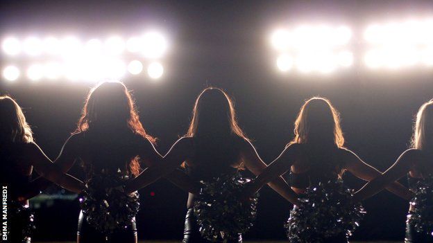 Cheerleaders in silhouette.