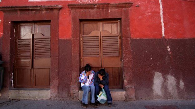 Mexican women sit outside a cantina