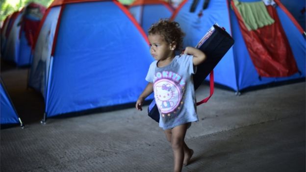 Young child walking between tents