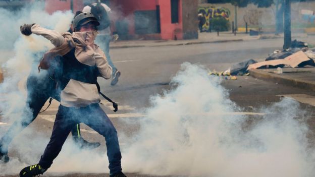 Joven devuelve un gas lacrimógeno a la policía.