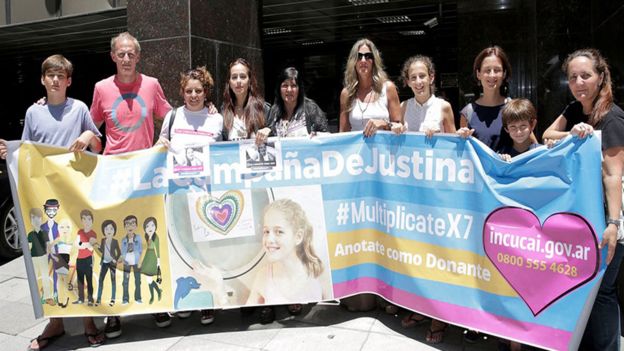 La familia de Justina con un afiche de su campaña