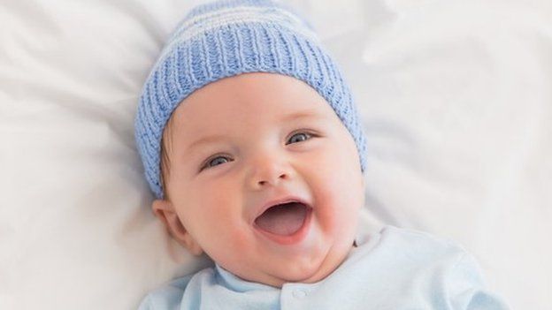 Laughing baby boy in blue hat