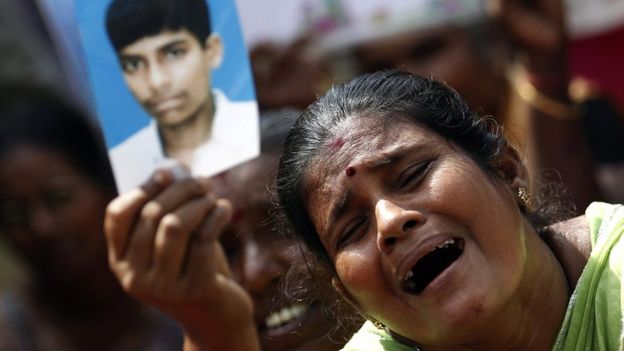 File picture of a Tamil woman crying as she holds up an image of her missing family member at a 2013 protest in Jaffna