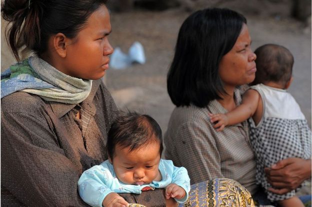 A woman holds a baby at a village on the outskirts of Siem Reap province, some 300 kilometers northwest of Phnom Penh on 22 February 2011.