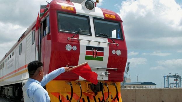 Man waving a red flag during the launch of the first batch of Standard Gauge Railway freight locomotives at Mombasa Port - January 11, 2017