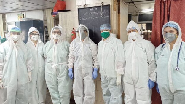 වෛද්‍යවරුන් හෙදියන් සහ අනෙකුත් කාර්ය මණ්ඩලය ආරක්‍ෂිත සායනික ඇඳුම් කට්ටල හැඳ සිටිති