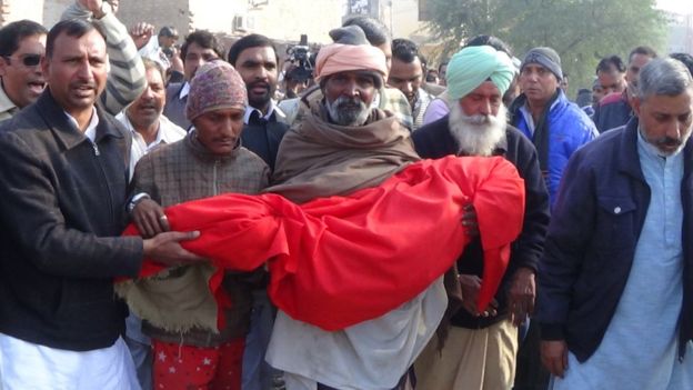 Locals carry the body of the six-year-old who was brutally raped and murdered