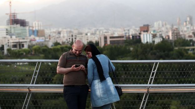 Una pareja de iraníes con un teléfono en Teherán