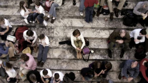 Un grupo de personas sentadas en una escalinata.