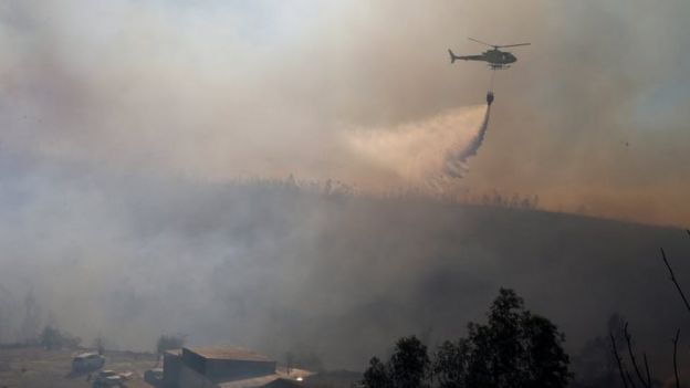 A helicopter drops water on a forest fire in Valparaíso, Chile. Photo: 24 December 2019