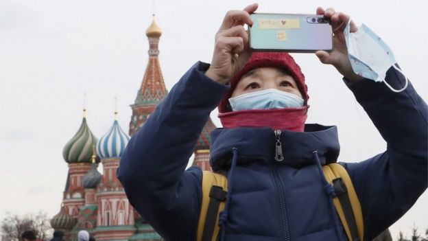 A Chinese tourist wearing a medical protection mask walks at the Red Square in Moscow, Russia, 26 January 2020