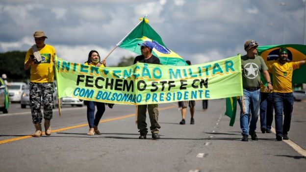 manifestantes carregam cartaz que pede intervenção militar com Bolsonaro presidente.