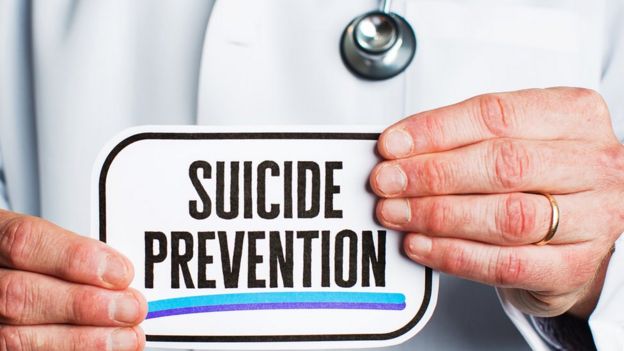 Médico con cartel de "Prevención de suicidios"