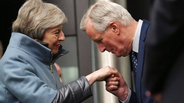 European Union chief Brexit negotiator Michel Barnier (R) kisses the hand British Prime Minister Theresa May (L)