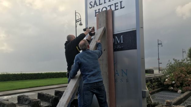 Two men working to support a sign