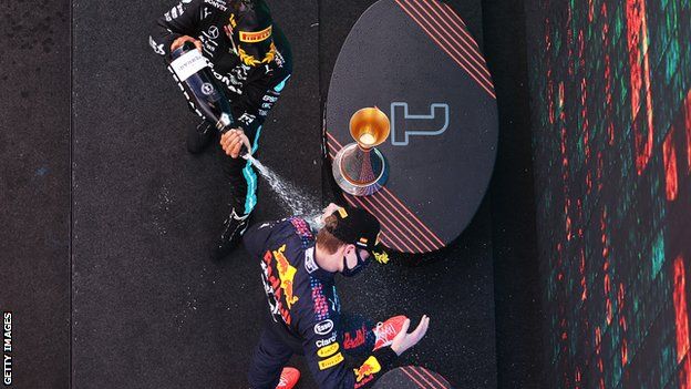 Lewis Hamilton sprays Max Verstappen with champagne