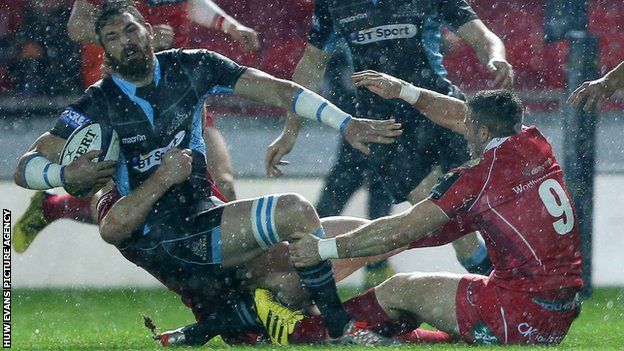 Glasgow winger Sean Lamont is tackled by Scarlets pair Jack Condy and Gareth Davies