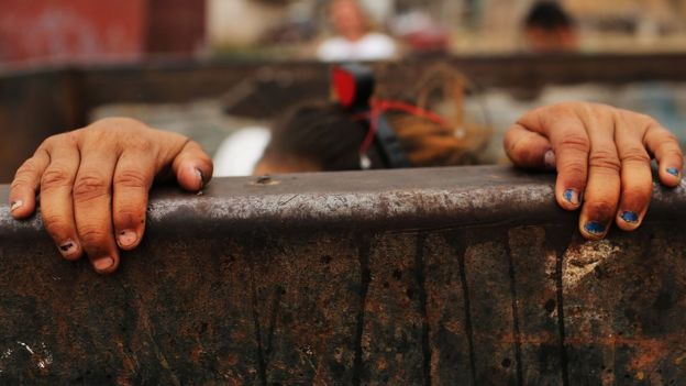 Niña juega en un basurero en Centroamérica