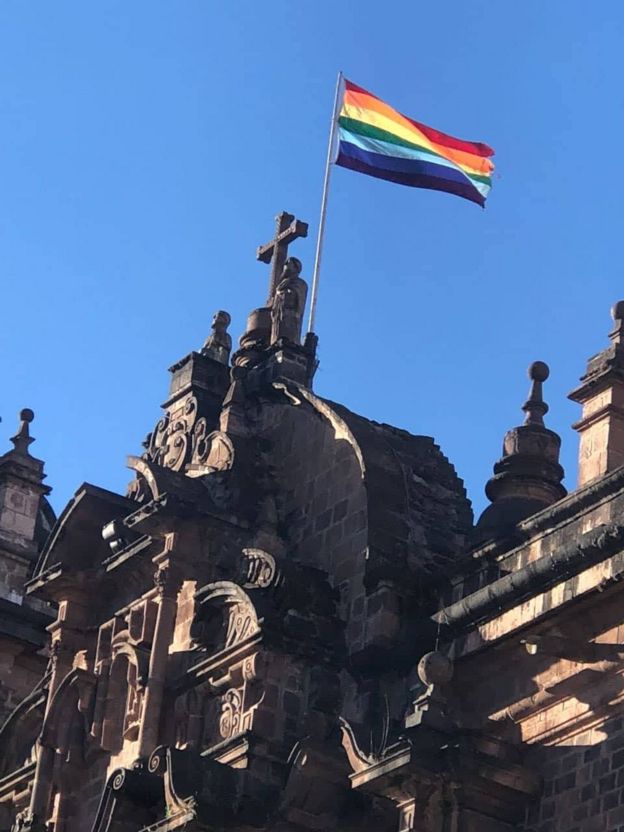 Bandeira do arco-íris de Cusco em fachada de igreja histórica