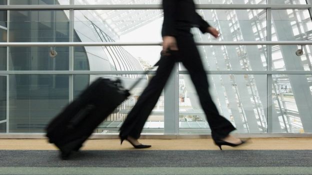 Una mujer arrastrando una maleta por un aeropuerto