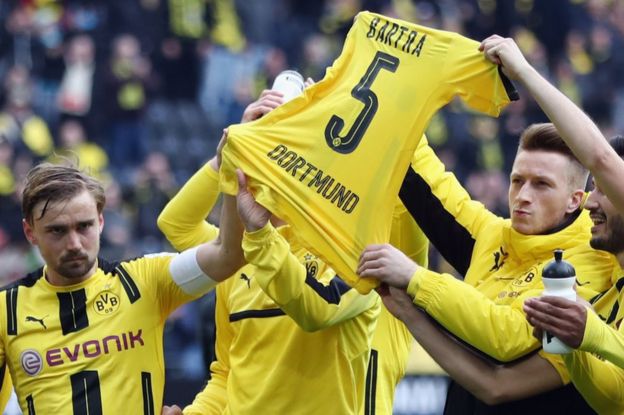 Después de ganar el partido de la Bundesligia contra el Eintracht Frankfurt el 15 de abril, los jugadores del Dortmund sostienen en alto la camiseta de su compañero Marc Bartra, herido en el ataque al bus del club el 11 de abril.
