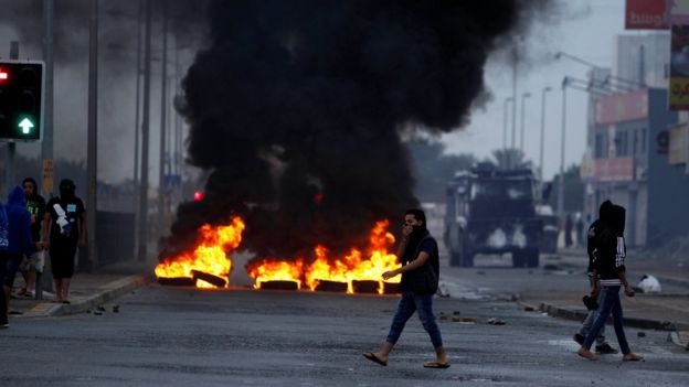 Anti-government protesters burn tyres and block a road during a protest to mark the 6th anniversary of the 14 February uprising in Bahrain, in the village of Sitra, south of Manama (14 February 2017)