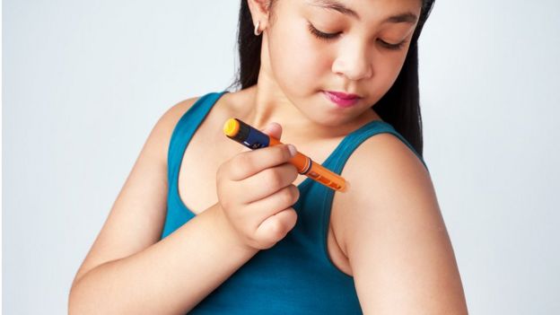 Una niña inyectándose insulina.