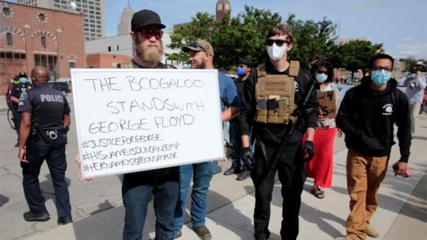 Armed men, one carrying a sign reading "The Boogaloo stands with George Floyd", are seen as protesters rally against the death in Minneapolis police custody of George Floyd, in Detroit, Michigan (May 30, 2020)
