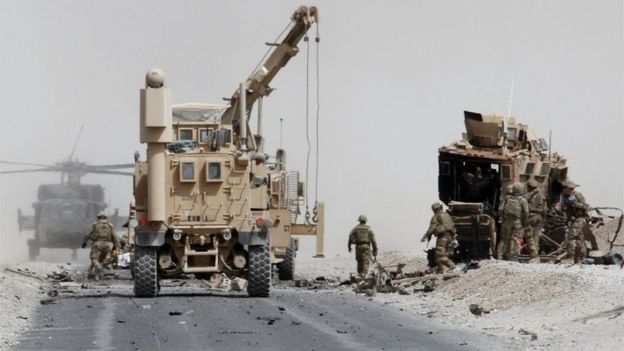 US troops assess the damage to an armoured vehicle of Nato-led military coalition after a suicide attack in Kandahar province, Afghanistan. Photo: August 2017