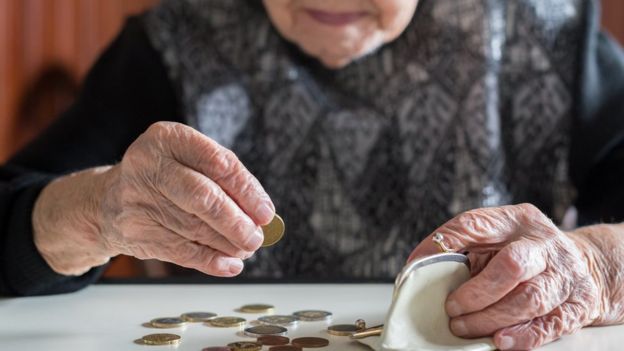Mulher idosa contando dinheiro