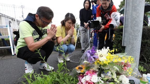 Residents pray for victims of a fire which hit the Kyoto Animation company studio